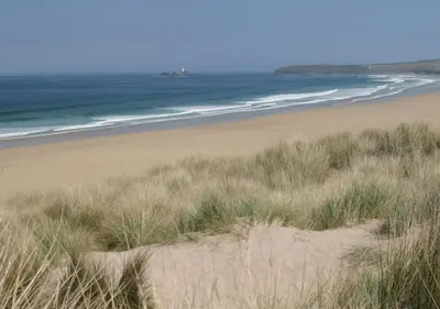 a view of a beach with grass and the ocean at D06 Heloan D6, Riviere Towans in Hayle