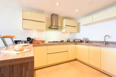 a kitchen with yellow cabinets and a sink at Ocean View in Carbis Bay