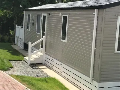 a storage shed with a door and a porch at Luxury Holiday Home Sleeps 6 Pet Friendly in St Austell