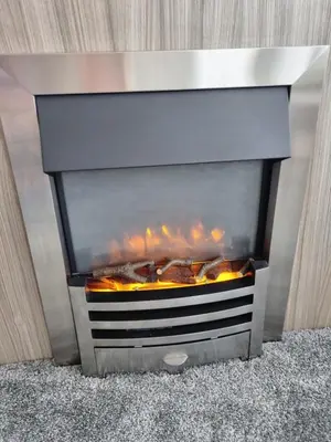 a fireplace with a fire inside of it at Seven Sunsets, Padstow in Padstow