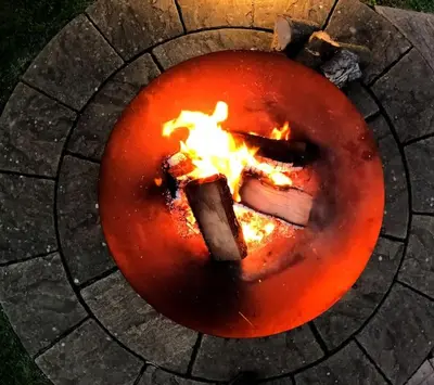 a fire pit with flames in the middle of it at Romantic Retreat - Luxury Shepherds Hut + Hot Tub! in Camborne