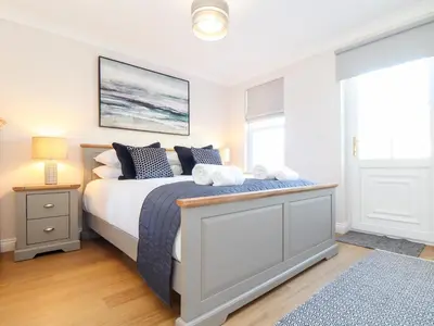 a bedroom with a king sized bed with blue and white pillows at Gweal in Truro