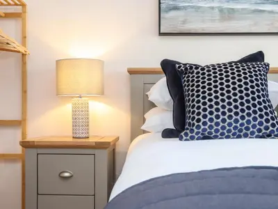 a bedroom with a bed and a lamp on a night stand at Gweal in Truro