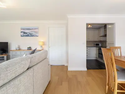 a living room and kitchen with a couch and a table at Gweal in Truro