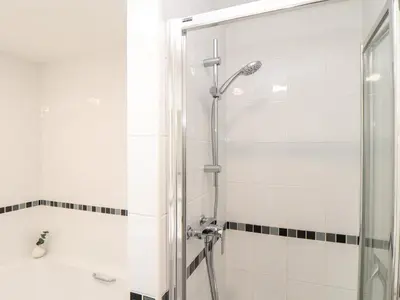 a bathroom with a shower and a tub and a sink at Gweal in Truro