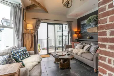 a living room with a couch and a table at Marners Rock No 2 in Fowey