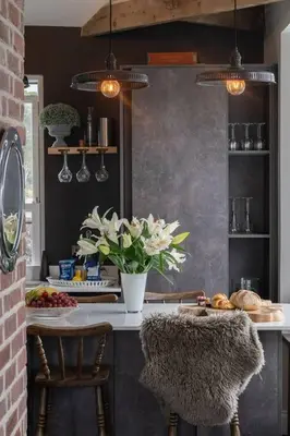 a kitchen with a counter with chairs and a table with flowers at Marners Rock No 2 in Fowey