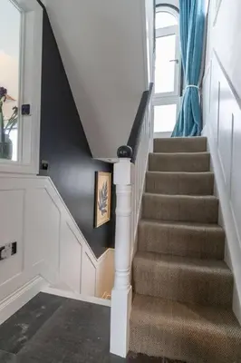 a staircase in a house with a blue curtain at Marners Rock No 2 in Fowey