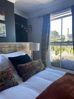 a bedroom with a white bed with a window at Marners Rock No 2 in Fowey