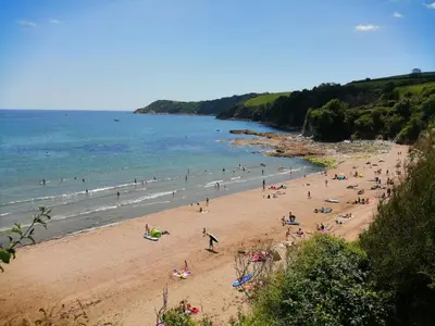a group of people on a beach near the ocean at Sea View in St Austell
