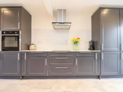 a kitchen with gray cabinets and a vase of flowers at Pickney House in Looe