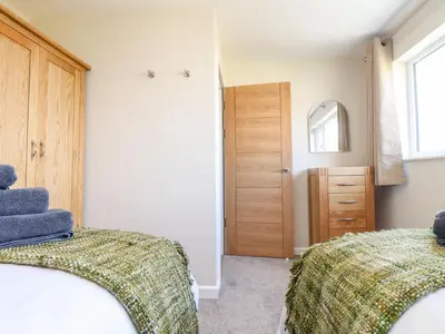 a bedroom with two beds and a mirror at Pickney House in Looe