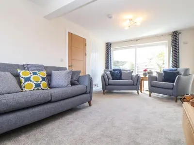 a living room with a couch and two chairs at Pickney House in Looe