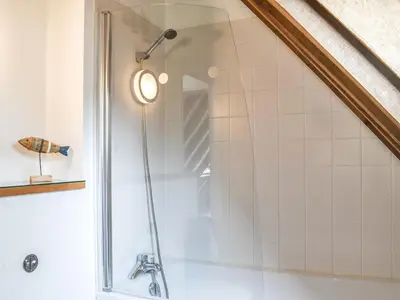 a shower with a glass door in a bathroom at Chy An Dour in Davidstow