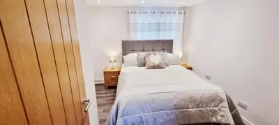 a bedroom with a large bed and a window at Looe Holiday Home Cornwall Sleeps 2 Self Catering No Pets in Looe