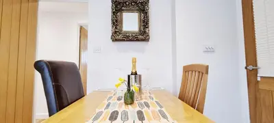 a table with a vase with flowers on it at Looe Holiday Home Cornwall Sleeps 2 Self Catering No Pets in Looe