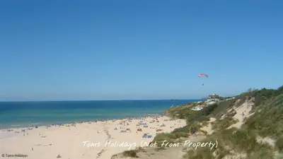 a group of people on a beach flying a kite at F40 Bayford, Riviere Towans in Hayle