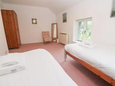 a bedroom with two beds and a window at Sunnyvale Cottage in Penzance