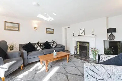 a living room with couches and a table and a fireplace at Myrtle Cottage Boscastle in Boscastle