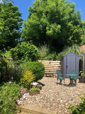 a garden with two chairs and a table and a bench at Knocker Cottage is a 3 bedroom made up of 1 double bedroom and 2 small double bedrooms in small village 10 min to beaches in Camborne