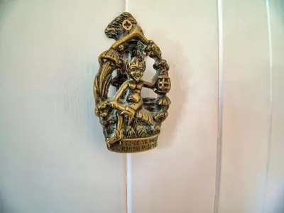 a gold object is hanging on a wall at Knocker Cottage is a 3 bedroom made up of 1 double bedroom and 2 small double bedrooms in small village 10 min to beaches in Camborne