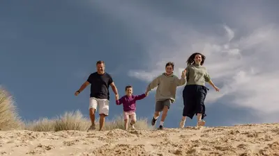 a family running on the sand on a beach at F75 Bronvellan, Riviere Towans in Hayle