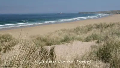 a sandy beach with grass and the ocean at G05 Horizon G5, Riviere Towans in Hayle