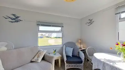 a living room with a couch and a table and a window at G05 Horizon G5, Riviere Towans in Hayle