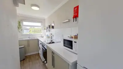 a white kitchen with a sink and a microwave at G05 Horizon G5, Riviere Towans in Hayle