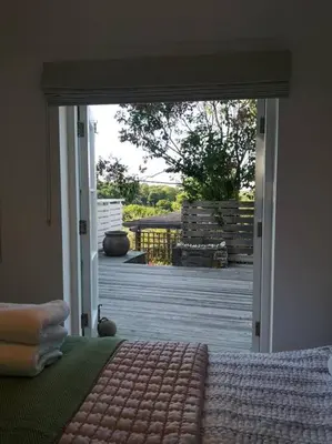a bedroom with a door open to a patio at The little post house. A perfect village retreat, with stunning views. in Boscastle