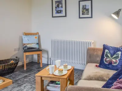 a living room with a couch and a table at Bolivar Barn in Gwennap