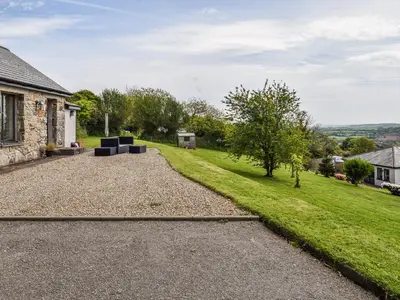 a house with a gravel driveway and a yard at Bolivar Barn in Gwennap
