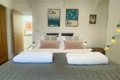 a bedroom with a large bed with two pillows at Luxury holiday cottage by the harbour in St Mawes in Saint Mawes