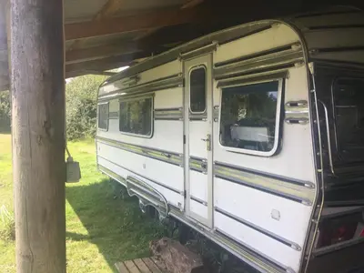 an old white train car sitting under a roof at The Quarry Caravan in Falmouth