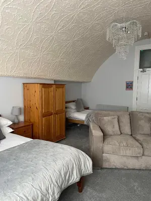 a bedroom with a couch and a bed and a bed and a room with at The Lugger Fowey in Fowey