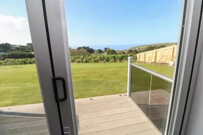 a door to a balcony with a view of a field at Greenside Studio in Penzance