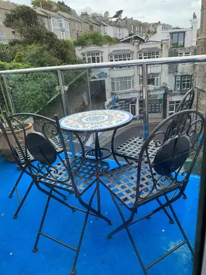 a patio table and two chairs on a balcony at Harbour View in St Ives